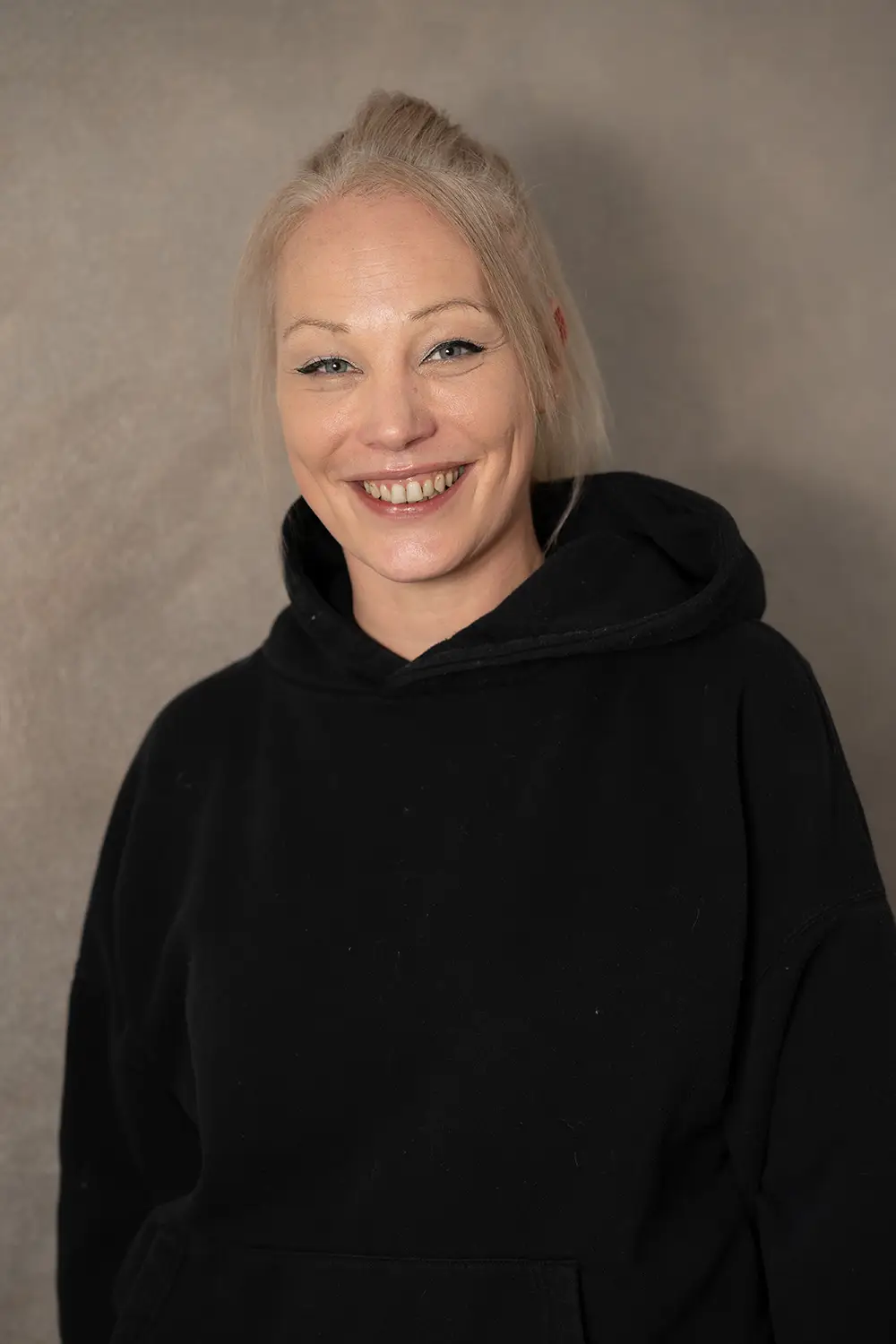 Portrait einer weiblichen Trainerin im schwarzen Hoodie im Fitnessstudio Body & Soul in Billerbeck, freundlicher Blick in die Kamera.