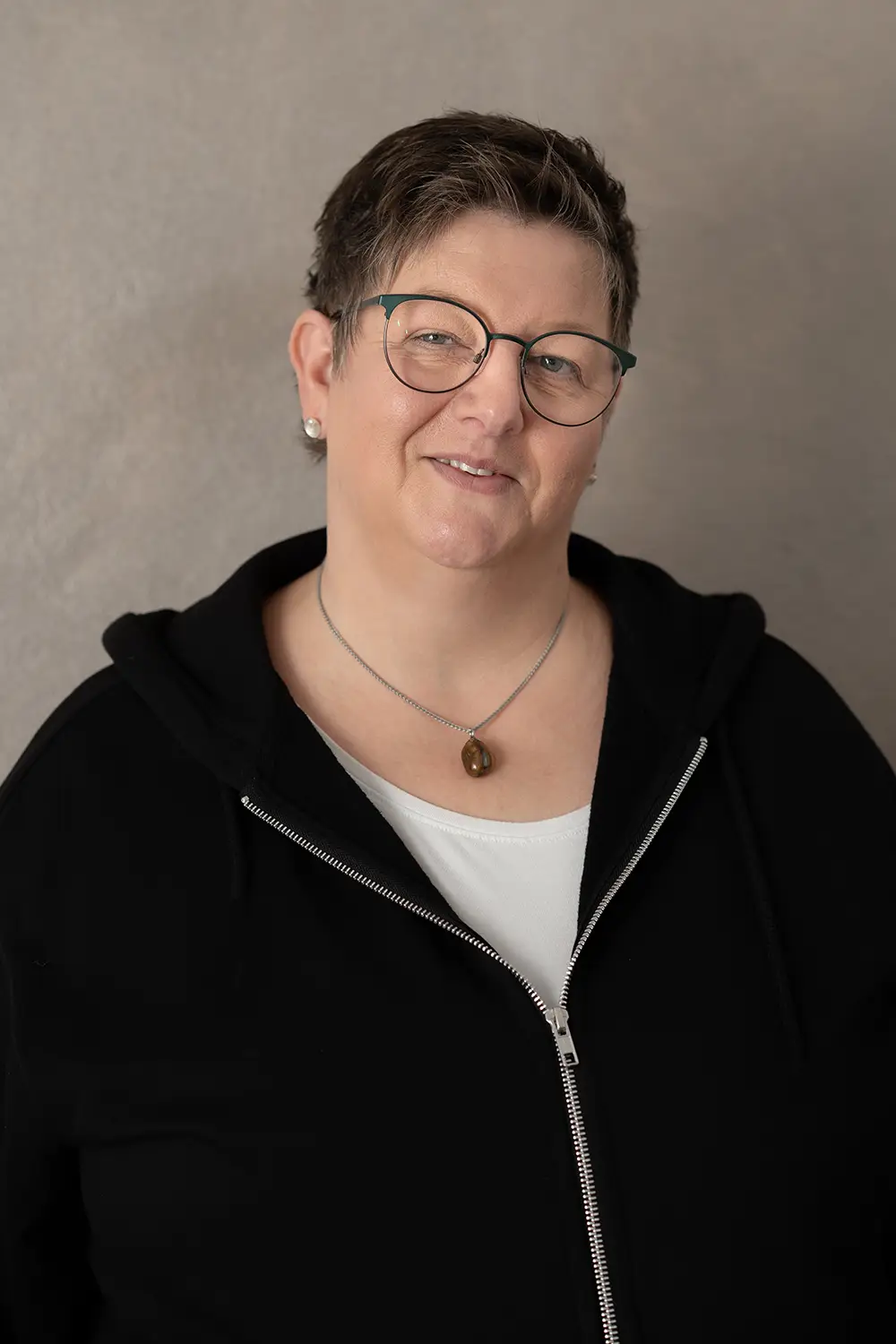 Portrait einer weiblichen Trainerin im schwarzen Hoodie im Fitnessstudio Body & Soul in Billerbeck, freundlicher Blick in die Kamera.