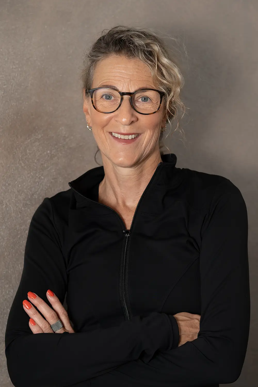 Portrait einer weiblichen Trainerin im schwarzen Hoodie im Fitnessstudio Body & Soul in Billerbeck, freundlicher Blick in die Kamera.