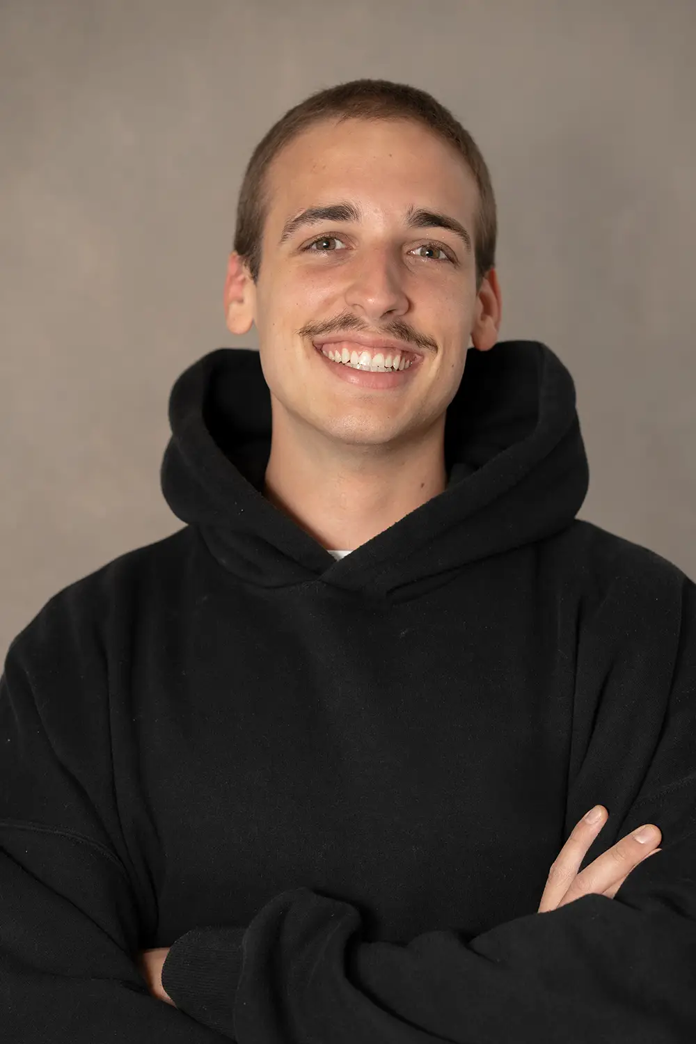 Portrait eines männlichen Trainers im schwarzen Hoodie im Fitnessstudio Body & Soul in Billerbeck, freundlicher Blick in die Kamera.