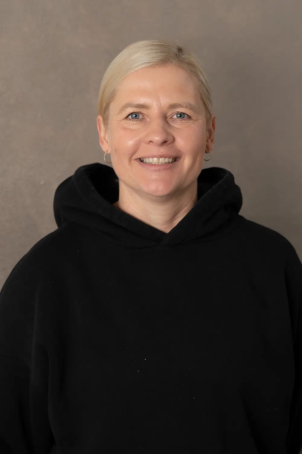 Portrait einer weiblichen Trainerin im schwarzen Hoodie im Fitnessstudio Body & Soul in Billerbeck, freundlicher Blick in die Kamera.