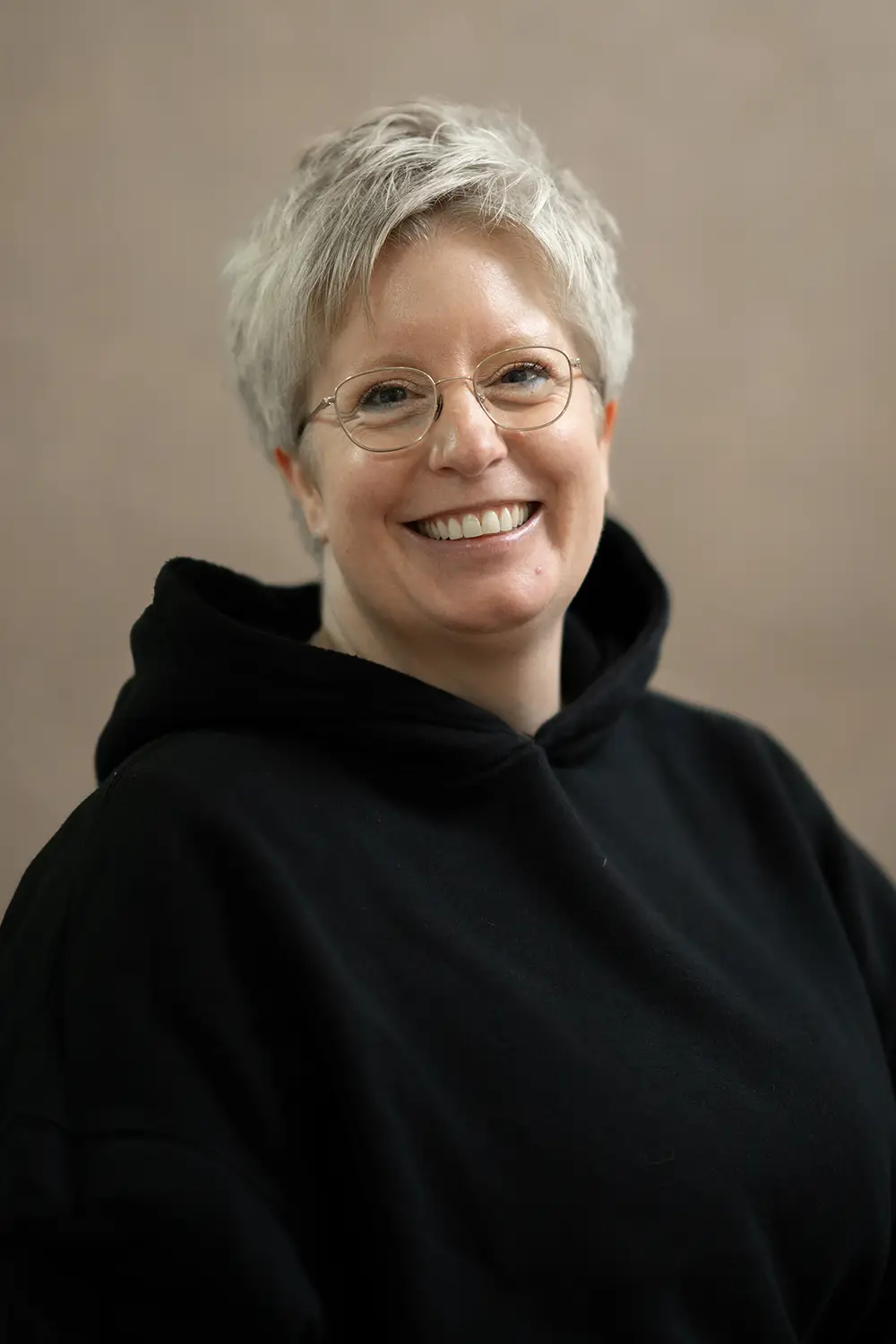 Portrait einer weiblichen Trainerin im schwarzen Hoodie im Fitnessstudio Body & Soul in Billerbeck, freundlicher Blick in die Kamera.