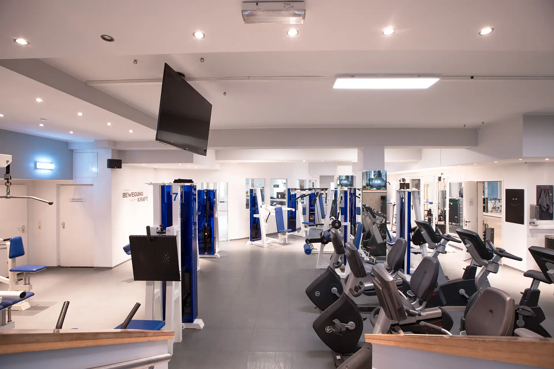 Heller Trainingsbereich im Fitnessstudio Body & Soul in Billerbeck mit Kraftgeräten, Cardiomaschinen, Spiegelwand und großer Trainingsfläche unter moderner Deckenbeleuchtung