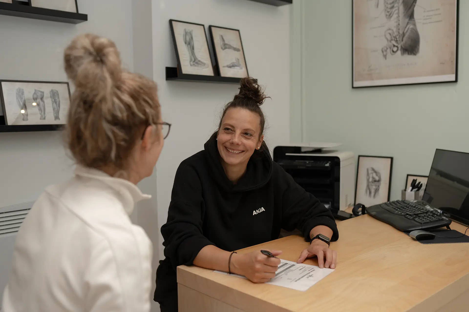 Trainerin führt ein persönliches Beratungsgespräch mit einem Mitglied am Tisch im Fitnessstudio Body & Soul in Billerbeck und füllt gemeinsam mit ihr einen Trainings- oder Anamnesebogen aus.