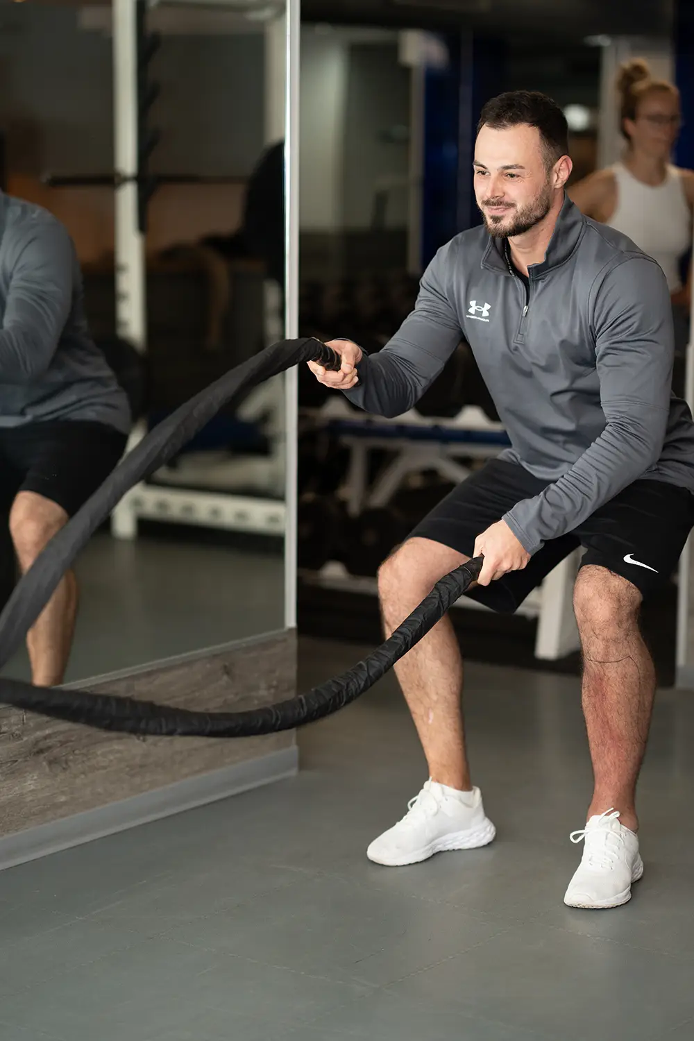 Trainer führt ein funktionelles Krafttraining mit schweren Seilen im Fitnessstudio body & soul Billerbeck durch, während eine weitere Person im Hintergrund trainiert